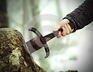 Knight tries to remove Excalibur sword in the stone