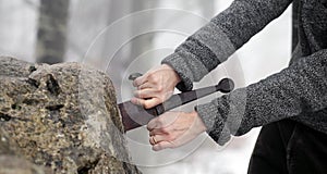 Knight tries to remove Excalibur sword in the stone