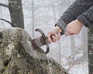 Knight tries to remove Excalibur sword in the stone