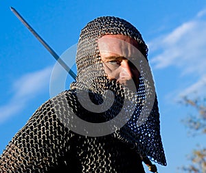 Knight wearing armour and hold on a sword