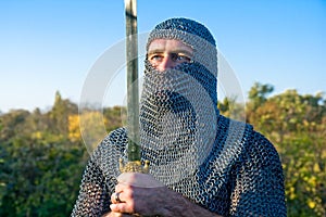 Knight wearing armour and hold on a sword