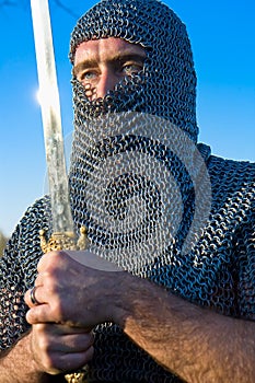 Knight wearing armour and hold on a sword