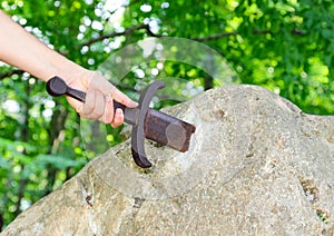 Knight who tries to extract the Excalibur Sword stuck in the rock in the middle of the forest