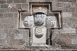 Knightly coat of arms on the wall of a house in Rhodes. photo
