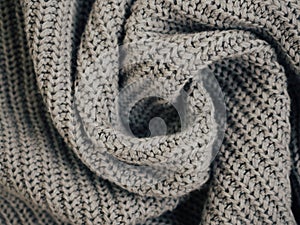 Knit grey fabric texture, background or backdrop. Textile, Crumpled gray scarf or sweater textured surface. Warm accessories,