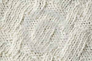 Knit texture of white wool knitted fabric with cable pattern as background.