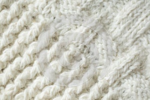Knit texture of white wool knitted fabric with cable pattern as background.