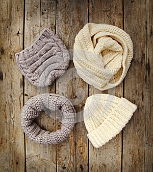 Knit Wool Hats ans Scarfs on wooden background.