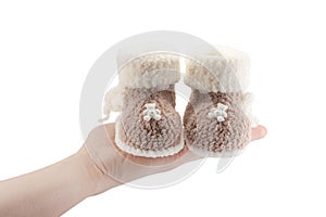 Knitted baby booties for newborn on hand isolated on white