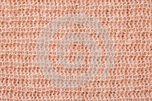 Knitted background. Texture of rough knitting from beige woolen threads