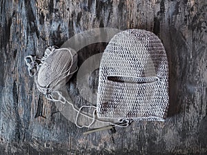 Knitted balaclava made of gray yarn, hook and skein of thread