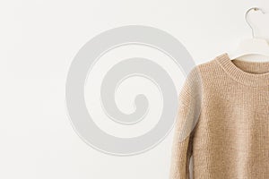 Knitted beige wool pullover on white background