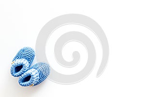 Knitted blue footwear for baby on white background top view mockup