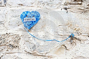 Knitted blue heart with the inscription kidnapped on stone wall demanding return of all hostages taken by Hamas