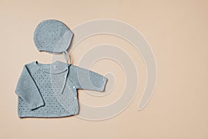 Knitted blue sweater and hat. Set of baby stuff and accessories for newborn on beige backgroundd. Baby shower or baby