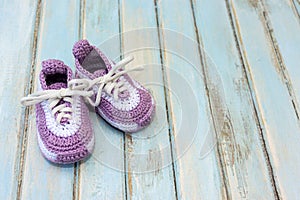 Knitted booties on a wooden background. Close-up of baby booties