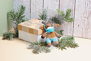 Knitted bull toy gift for 2021. Gift box, toy bull and fir twigs on geometric background