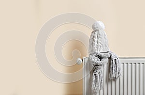 Knitted cap and scarf on heating radiator