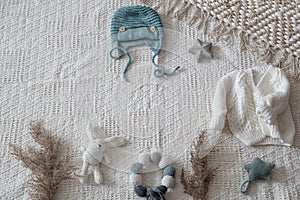 Knitted children`s clothing on a light background with accessories