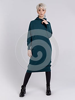 Knitted clothes on show on the girl in the studio on a white background