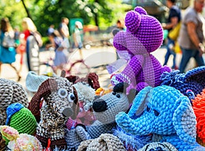 Knitted colorful toys of different animals in a street souvenir shop