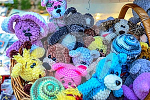 Knitted colorful toys of different animals in a street souvenir shop