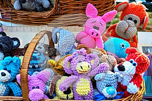 Knitted colorful toys of different animals in a street souvenir shop