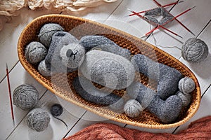 Knitted details of a toy teddy bear lying in a wicker basket