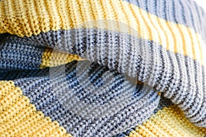 Knitted fabric large knitted yellow with grey stripes horizontally.