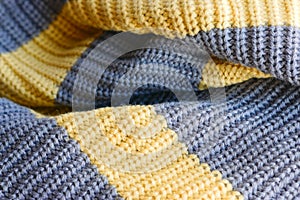 Knitted fabric large knitted yellow with grey stripes horizontally.