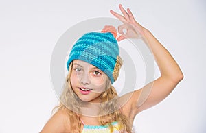 Knitted hat with pompon. Girl long hair happy face white background. Kid wear warm soft knitted blue hat. Difference