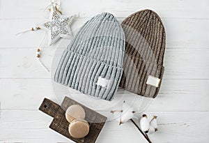 Knitted hats, cotton sprigs, macaroons close-up on a white