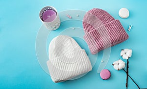 Knitted hats, cotton sprigs, macaroons close-up on a white