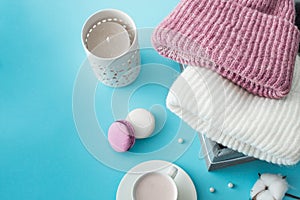 Knitted hats, cotton sprigs, macaroons close-up on a white