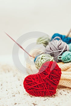 Knitted heart symbol and balls of yarn