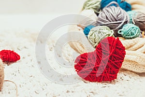 Knitted heart symbol and balls of yarn
