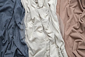 Knitted indigo, beige and brown fabrics, draped jersey cloths background