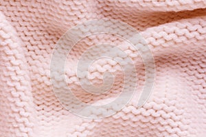 Knitted light pink fabric texture with large fold, reverse stockinette stitch