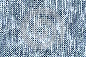 Knitted melange background from woollen yarns in blue and white colors. Abstract grunge texture of a knitted fabric