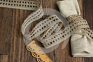 Knitted openwork linen ribbon tapes in rural style of rustics cotton eco natural on wood ground