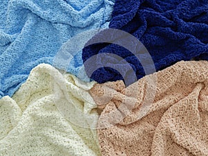 Knitted plaids of different colors. Background. Creases on soft surfaces
