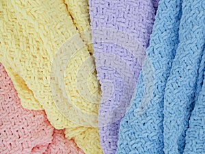 Knitted plaids of different colors. Background. Creases on soft surfaces