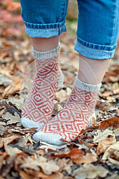 Knitted socks on the background of leaves