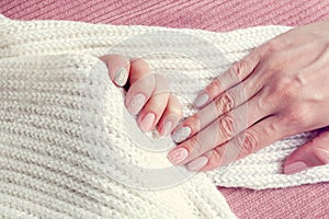 Knitted texture manicure on nails from pink and gray colors