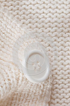 Knitted texture with a white button