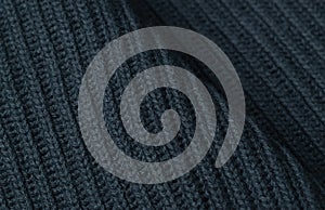 Knitted textured background of dark gray color. Close-up of knit and purl loops.