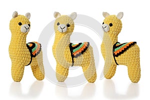 Knitted toy. Yellow lama on white background. Three position. Full depth of fiel