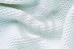 Knitted white fabric texture with large fold, reverse stockinette stitch