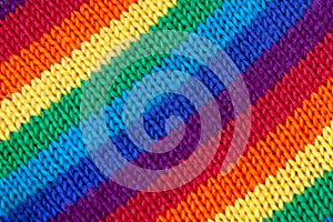 A knitted wool fabric in the colors of the rainbow. Fun background. Diagonal stripes.