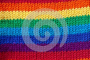 A knitted wool fabric in the colors of the rainbow. Fun background. Horizontal stripe.